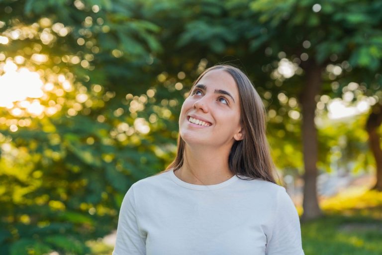 A woman enjoying a peaceful moment outdoors in warm sunlight